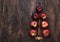 Creative Christmas tree made from red apples, cinnamon and anise star on wooden brown background