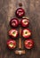 Creative Christmas tree made from red apples, cinnamon and anise star on wooden brown background