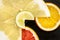 Creative citrus fruits slice on a black background, abstract. lemon, orange, lime, grapefruit, sweetie, pomelo