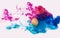 Creative color overflow concept of painting Easter egg. An explosion of neon colors pink and blue on white background