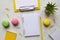 Creative colorful table desk. Workspace with notepads, pencil, plant, and macaroons on marble background. Top view, flat