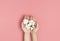 Creative composition with cotton. Hands of young woman holding white cotton flowers on pink background. Top view flat lay copy