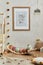 Creative composition of cozy scandinavian child`s room interior with mock up poster frame, balance board, plush toys and textile.
