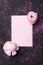 Creative composition with pink paper blank and beautiful ranunculus flower on black table top view for wedding mockup flat lay