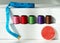 Creative composition with spools of colored threads and scissors. Sewing accessories, tailoring set.