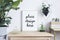 Creative composition of stylish home interior design with mock up poster frame, wooden commode, plants in designed pots.