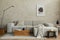 Creative composition of stylish japandi living room with mock up poster frame, grey sofa, wooden cubes, design vases and small.