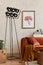 Creative composition of stylish living room interior with mock up poster frame, orange sofa, industrial lamp, coffee table.