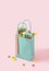Creative concept of a blue shopping bag full of delicious sweets from the candy store. Pastel pink background
