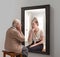 Creative conceptual collage. Senior woman looking in mirror and remembering her past. Young girl in reflection. Aging