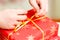 Creative diy craft hobby. Making handmade craft ribbon with hands. Female hands with red gift box close up. Selective focus umage