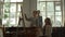 Creative family painting in studio. Young woman sitting near easel with children