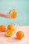 Creative and fashionable photo, pastel colors. Female hand crushes orange, juice