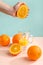 Creative and fashionable photo, pastel colors. Female hand crushes orange, juice.