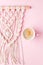 Creative flat lay concept, coffee cup and macrame panel on pastel pink background and copy space, minimal style, saint valentine