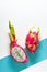 Creative flat layout with fresh organic pink, white and green dragonfruit pitaya or pitahaya on two tone split blue mint and