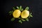 Creative fresh ripe lemons and mints leaves on dark stone background. Top view with copy space