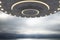 Creative grey UFO flying in dull sky with mock up place. Spaceship, invasion, mystery and science concept.