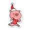 A creative happy distressed sticker cartoon of a pig running wearing santa hat
