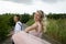 Creative hipster wedding by the sea. The bride is in a pink dress and veil, the groom is in beautiful trousers with suspenders and