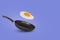 Creative idea with a frying pan and a flying fried egg on a purple background. Creative food concept