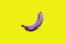 Creative idea purple banana on a yellow background