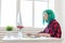 Creative, illustrator and designer concept - happy woman with green hair is drawing a project