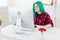 Creative, illustrator and designer concept - happy woman with green hair is drawing a project