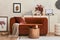 Creative interior composition of living room with mock up poster frame, designed couch, coffee table, vintage record-player, pouf.