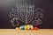 Creative Jewish holiday Hanukkah background with spinning top dreidel over chalkboard with hand drawing