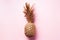 Creative layout. Gold pineapple on pink background with copy space. Top view. Tropical flat lay. Exotic food concept, crazy trend