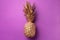 Creative layout. Gold pineapple on violet background with copy space. Top view. Tropical flat lay. Exotic food concept, crazy