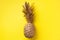 Creative layout. Gold pineapple on yellow background with copy space. Top view. Tropical flat lay. Exotic food concept, crazy