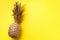 Creative layout. Gold pineapple on yellow background with copy space. Top view. Tropical flat lay. Exotic food concept, crazy