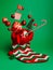 Creative layout made with Christmas socks and flying Santa Claus, pine tree, gift boxes and candy cane on green background. Minima