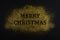 Creative layout made of golden glitter with sign `Merry Christmas` on black paper background.