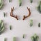 Creative layout made of reindeer antlers and Christmas tree branches on beige background.