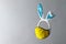 Creative levitation composition with cyan bunny ears headband and yellow protective face mask on gray background