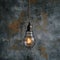 Creative lighting hanging lightbulb on industrial cement background