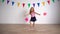 Creative little girl pretending cheerleader holding pink pompon paper balls