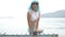 Creative look of woman on the beach wearing bikini, blue wig, black leather fingerless gloves and sunglasses - slow motion video.