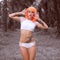 Creative look of woman in orange wig in palm trees forest