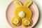 Creative meal for a child, pancake with banana, chocolate and whipped cream in a rabbit shape