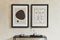 Creative minimalistic composition of stylish modern living room interior with two mock up poster frames, black geometric commode.