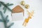 Creative mockup with gift wrappers tied with gold ribbons, envelope with blank paper and braided deer on light background. Copy