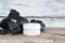 Creative mockup with white jar of cream on a wooden background. A pile of natural coal in the background. Skin care concept