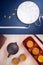 Creative Moon cake Mooncake design inspiration, enjoy the moon in Mid-Autumn festival with pastry and tea on wooden table concept