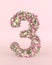Creative number 3 concept made of fresh Spring wedding flowers. Flower font concept on pastel pink background