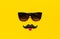 Creative party decoration concept. Black mustache, Sunglasses, props for photo booths, carnival parties on yellow background top