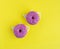 Creative pattern of donuts covered with pink icing and colored pastry topping.